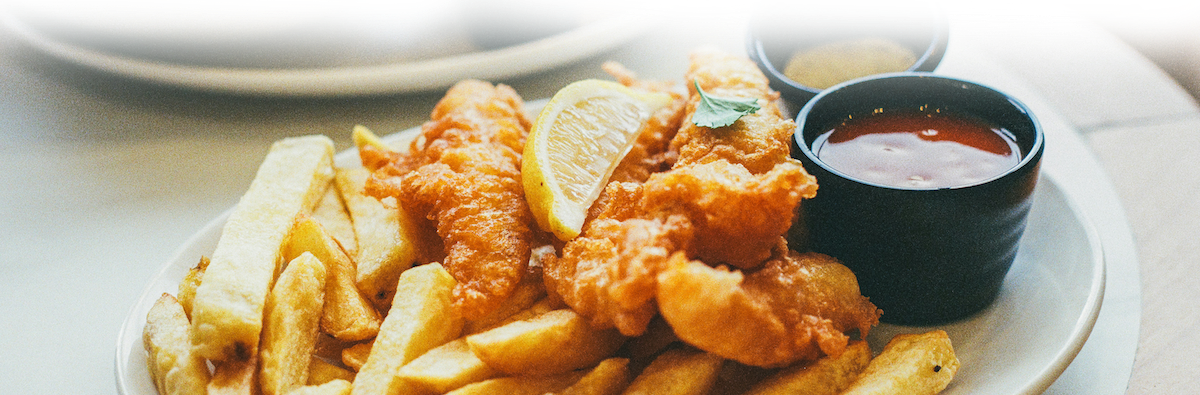A plate of fried fish and french fries with dipping sauce.