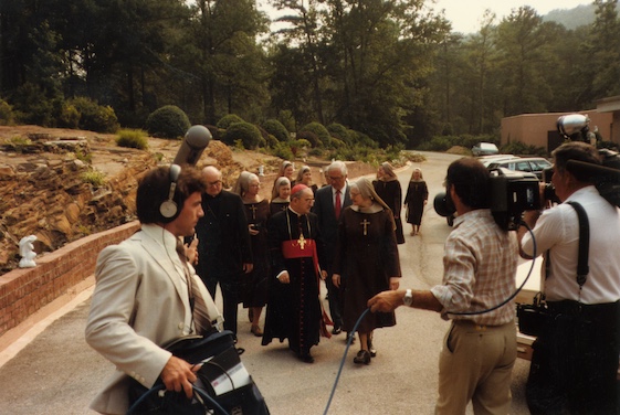 Mother Angelica conversing with Bishop Foley, surrounded by a film crew.